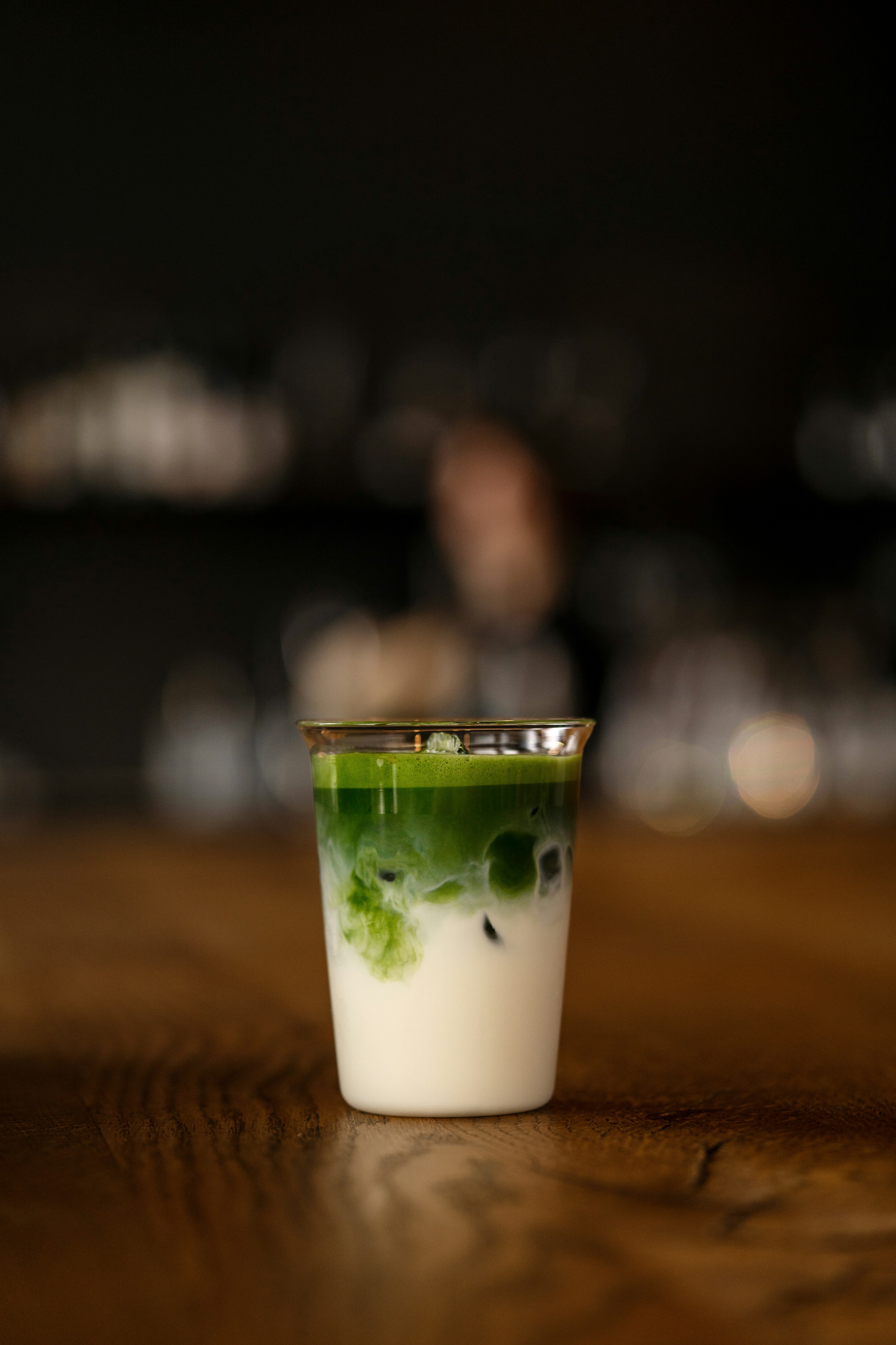 Iced matcha latte layered with milk on a cafe counter